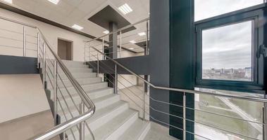 loop rotation and panoramic view in empty modern hall with emergency and evacuation exit stair, columns, doors and panoramic windows. video