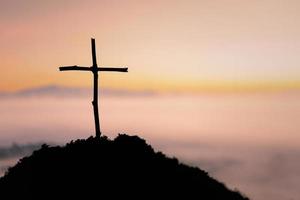 Crucifixion Of Jesus Christ - Cross At Sunset. The concept of the resurrection of Jesus in Christianity. Crucifixion on Calvary or Golgotha hills in holy bible. photo