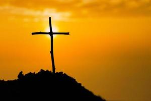 Crucifixion Of Jesus Christ - Cross At Sunset. The concept of the resurrection of Jesus in Christianity. Crucifixion on Calvary or Golgotha hills in holy bible. photo