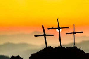 Crucifixion Of Jesus Christ - Cross At Sunset. The concept of the resurrection of Jesus in Christianity. Crucifixion on Calvary or Golgotha hills in holy bible. photo