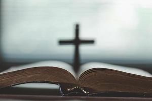 Holy bible book for education on wooden table with background. Christian catholic with protestant worship and pray in church. Concept of learning about faith god and religion, jesus spiritual. photo