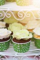 Wedding chocolate Cupcakes in green cup with garland lights bokeh and sunlight background photo