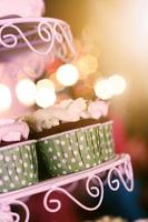 Wedding Cupcakes with colorful sprinkles in green cup with garland lights bokeh background photo