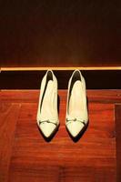 blanco calzado para mujer con grueso alto tacones.moda mujer Zapatos en wodden piso. foto