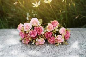 Pink Roses bouquet on concrete floor in the garden with sunlight and green natural background. Valentine Day for love and celebration Concept. photo