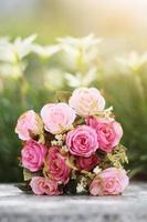 Pink Roses bouquet on concrete floor in the garden with sunlight and green natural background. Valentine Day for love and celebration Concept. photo