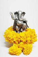 Ganesha god is the Lord of Success God of Hinduism on Marigold flowers Isolated on white background. photo