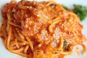 espaguetis con tomate salsa en blanco plato foto