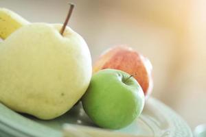 chino pera, verde y rojo manzanas sobre vidrio plato foto