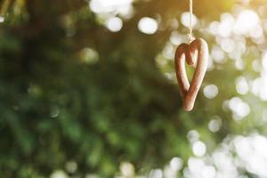 forma de madera corazón colgando en techo Decorar en Boda ceremonia. enamorado día concepto foto