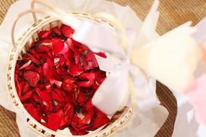 hermosa rojo Rosa pétalos flores en cesta decorado en Boda ceremonia foto