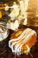 Ceramic cup and holy thread with holy water's a buddhist in Gold tray and gold bowl for Thai engagement ceremony.Thai wedding culture tradition photo