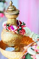 Golden vase with Jasmine garland in tradition Thai wedding ceremony. photo