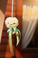 White bouquet flowers with ribbon hanging decoration in wedding ceremony photo