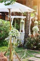 White birdcage decoration with roses and white flowers hanging decoration in garden for wedding ceremony photo