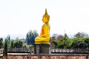 Golden Buddha statue and the old pagoda at ancient temple, Thailand photo