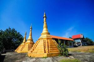 Golden pagoda detail is Mon architectural style at temple located in Kanchanaburi Province, Thailand. photo