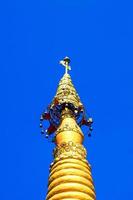 Golden pagoda detail is on architectural style at temple located in Kanchanaburi Province, Thailand. photo