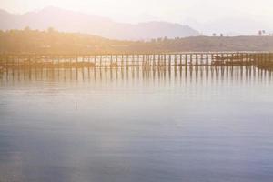 Beautiful sunrise on the Mon wooden Bridge with blue sky in sangkhlaburi, Thailand photo