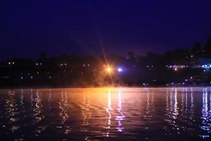 Beautiful Bokeh light and fog over river in the morning at countryside of Thailand photo