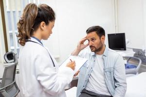 Patient receiving bad news, he is desperate and sad, Doctor support and comforting patient with sympathy. Don't worry, this medical test is not so bad photo