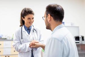 Young female doctor hold hand of caucasian man patient give comfort, express health care sympathy, medical help trust support encourage reassure infertile patient at medical visit photo