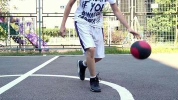 jong Mens spelen basketbal in park, selectief focus, lawaai effect video