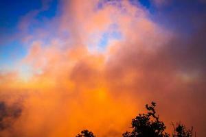 puesta de sol en cielo y nube, hermosa vistoso crepúsculo hora con silueta de montaña. foto