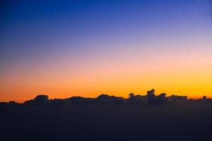 puesta de sol en cielo y nube, hermosa vistoso crepúsculo hora con silueta de montaña. foto