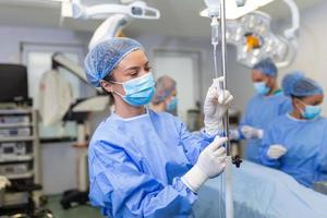 Female Doctor in the operating room putting drugs through an IV - surgery concepts photo