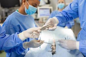 Shot in the Operating Room, Assistant Hands out Instruments to Surgeons During Operation. Surgeons Perform Operation. Professional Medical Doctors Performing Surgery. photo