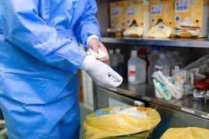 Male surgeon removing surgical gloves in operation theater at hospital photo