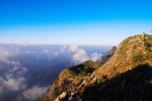 Sunrise in morning with sky and cloud on the mountain. Sunray with Fog and mist cover the jungle hill in Thailand photo