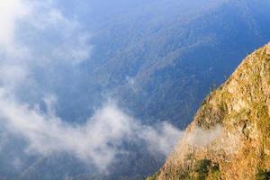 Sunrise in morning with sky and cloud on the Limestone mountain. Sunray with Fog and mist cover the jungle hill in Thailand photo