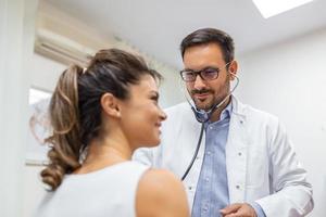 Caring Caucasian male doctor use phonendoscope examine female patient heart rate at consultation in hospital. Man GP use stethoscope listen to woman heartbeat in clinic. photo