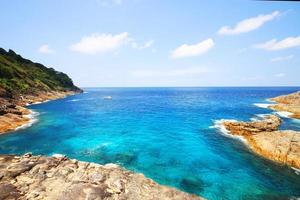 Beautiful paradise in summer of seascape and sea horizon with yacht boat in Calm ocean and blue sky on rock mountain Cape.Tropical Beach plants and jungle island photo