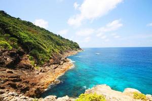 Beautiful paradise in summer of seascape and sea horizon with yacht boat in Calm ocean and blue sky on rock mountain Cape.Tropical Beach plants and jungle island photo