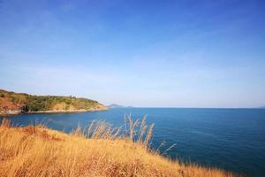 Beautiful seascape with sky twilight of sunset and sea horizon with Calm and blue sky.Dry grass field on mountain of Phrom Thep Cape is famous place in Phuket island, Thailand. photo