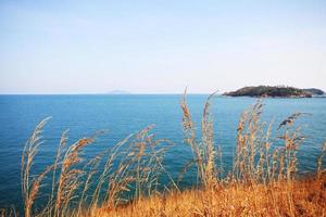 Beautiful seascape with sky twilight of sunset and sea horizon with Calm and blue sky.Dry grass field on mountain of Phrom Thep Cape is famous place in Phuket island, Thailand. photo