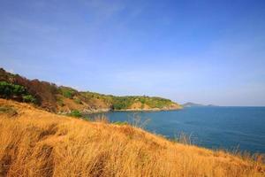 Beautiful seascape with sky twilight of sunset and sea horizon with Calm and blue sky.Dry grass field on mountain of Phrom Thep Cape is famous place in Phuket island, Thailand. photo