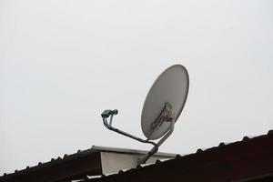 Satellite receiver antenna installed on roof. Concept, technology for communication, global broadcast for digital reception through TV. photo