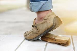 de cerca hombre usa Zapatos es pisar en oxidado metal uña en madera. concepto, inseguro , riesgo para peligroso tétanos. ser Cuidado y Mira alrededor durante caminando a construcción sitio o riesgo lugares. foto
