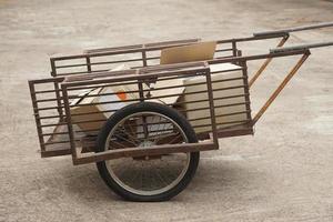 Wheel cart carries paper boxes.  Concept, DIY vehicle made from recycled metal bars design mix with two wheels for use as a cart to carry things. Transportation. photo