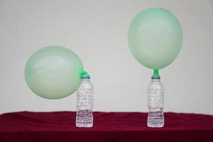 Inflated balloons on top of transparent test bottles. Concept, science experiment about reaction of chemical substance, vinegar and baking soda that cause balloon inflat. Last step of experiment photo