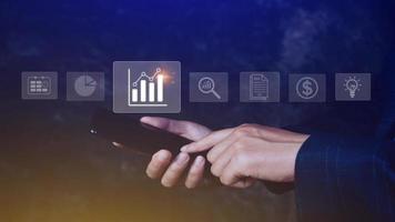 Data analytics and business intelligence BI concept with chart and graph icons on digital screen interface on smartphone and business people in the background. photo