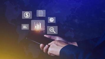 Data analytics and business intelligence BI concept with chart and graph icons on digital screen interface on smartphone and business people in the background. photo