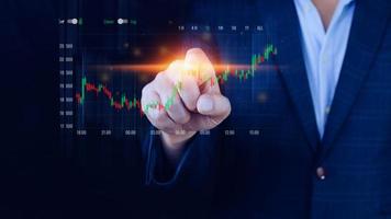 Businessman finger touch symbol stock graph and chart background, concept growth and development business investment, Stock market and strategy making market plan and stock market fluctuations photo