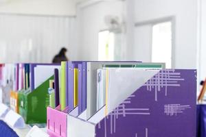 Colorful folders of personnel and office staff are kept and sorted in boxes in the office to evaluate their performance in order to raise their salary or increase their annual remuneration. photo