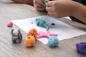 An autistic boy molding different shapes of colored plasticine prepared by parents at home in order to develop various aspects in their son which has slower brain development than normal children. photo