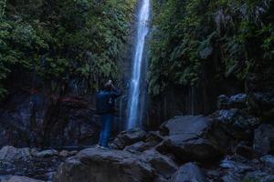 Lagoa das 25 Fontes. Tourist taking photo of waterfall. Madeira, Portugal